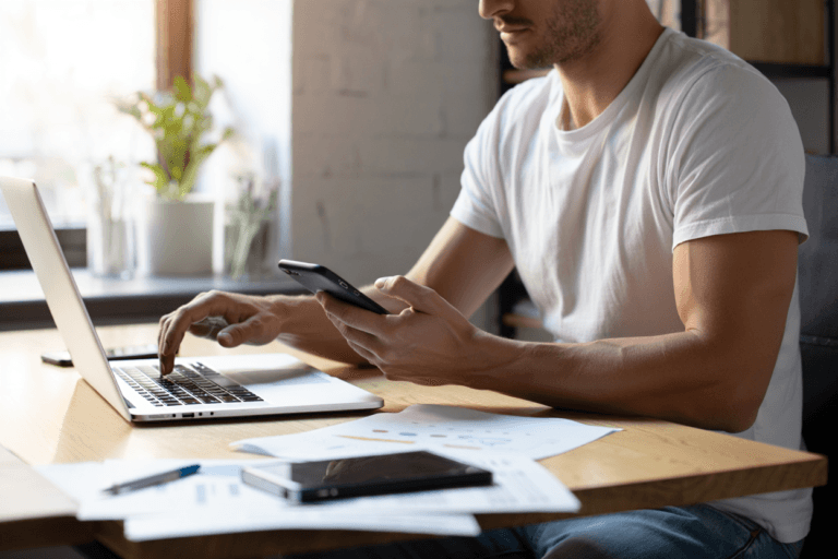 Person trying to manage multiple items on a desk, juggling DIY SEO.